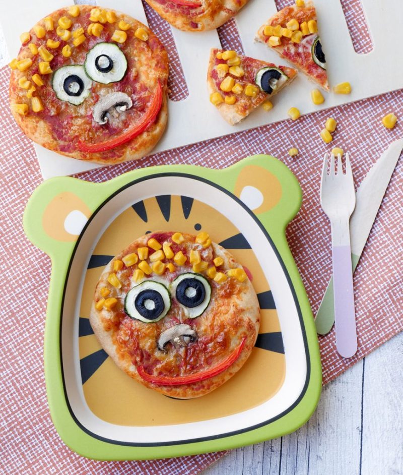  Fast children's pizza with funny face made of colorful vegetables 